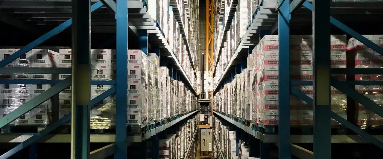 Allée d'entrepôt bordée de rayonnages chargés de cartons